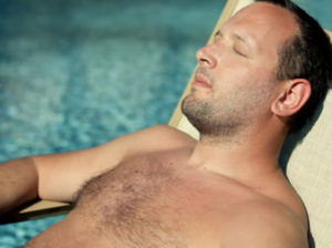 A man enjoying sunbathing on a hot yellow sand beach, promoting sun protection and skin health at our Sun Bath Center in Jaipur